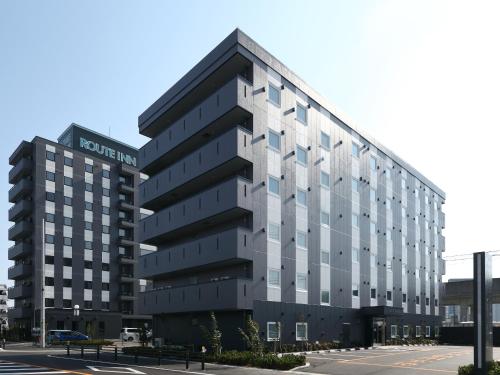 an office building in front of a parking lot at Hotel Route-Inn Tokoname Ekimae in Tokoname