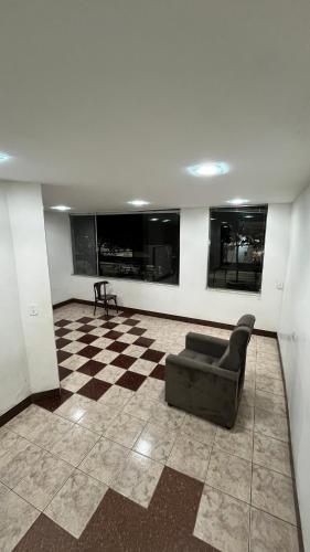 a living room with a couch and a checkered floor at Hotel Monick in Teixeira de Freitas