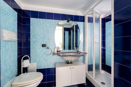 a blue tiled bathroom with a sink and a toilet at Casa Lauritano in Atrani