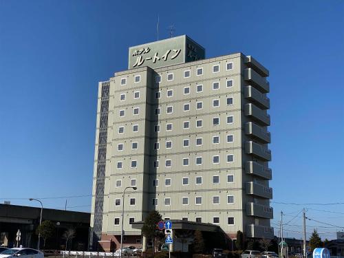 a tall building with a sign on the top of it at Hotel Route-Inn Hon Hachinohe Ekimae in Hachinohe