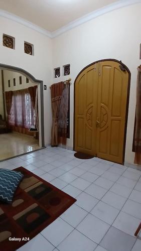 a room with two wooden doors and a tile floor at Rumah Syariah 4BR 150Mbps WiFi Bersih Lengkap Luas Nyaman in Batu Hampar