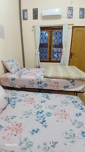 two beds sitting next to each other in a bedroom at Rumah Syariah 4BR 150Mbps WiFi Bersih Lengkap Luas Nyaman in Batu Hampar