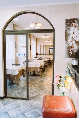 a mirror in a restaurant with tables and chairs at Hotel Magnolia in Albenga