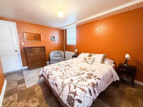 a bedroom with a bed with an orange wall at Peaceful Hideaway in Central Fargo in Fargo