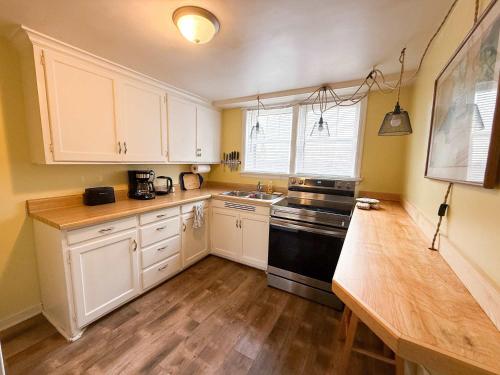a kitchen with white cabinets and a black stove at Peaceful Hideaway in Central Fargo in Fargo