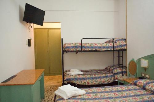 a room with two bunk beds and a table at Hotel Magnolia in Albenga