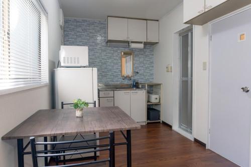 a kitchen with a table and a refrigerator at SORAHOME Direct access to city Manga & bicycle included in Tokyo