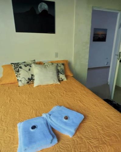 a bedroom with a bed with blue clothes on it at CASA DE TUCA in Ilhabela