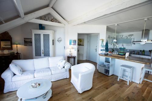un salon avec un canapé blanc et une cuisine dans l'établissement Les Palmiers, à Marseille