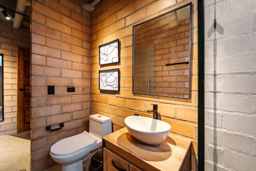 a bathroom with a white toilet and a sink at Otalu Suites in Medellín