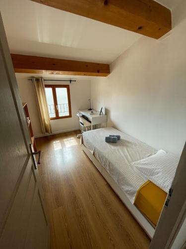 une chambre avec un lit blanc et un bureau dans l'établissement Maison pour vacances en famille, à La Celle-sous-Gouzon