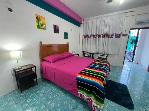 a bedroom with a large bed with a colorful blanket at Casa Margarita Mexican Warmth Await! in Cozumel