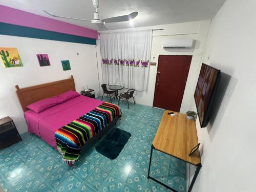 a bedroom with a pink bed and a table at Casa Margarita Mexican Warmth Await! in Cozumel