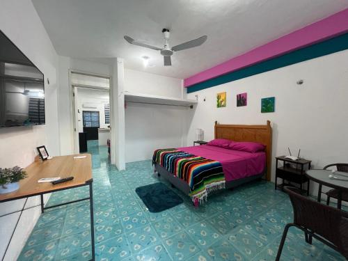 a bedroom with a bed and a table and a desk at Casa Margarita Mexican Warmth Await! in Cozumel