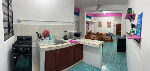 a small kitchen with a sink and a stove at Casa Margarita Mexican Warmth Await! in Cozumel