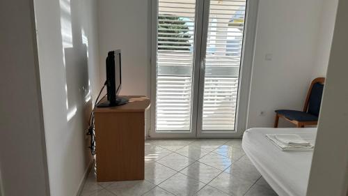 a room with a bed and a television on a dresser at Apartment Palma - Novalja in Novalja