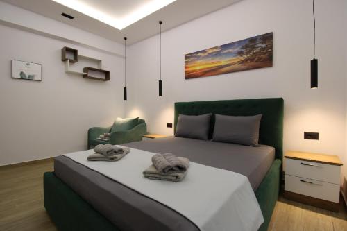 a bedroom with a large bed and a chair at Vila Eni - Mario in Ksamil