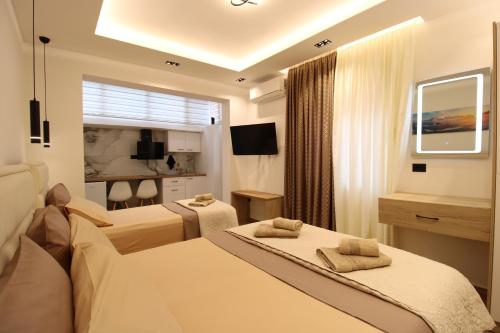 a hotel room with two beds and a television at Vila Eni - Mario in Ksamil