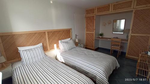 a hotel room with two beds and a desk at Aegean Villita on beach apartment in Kalymnos