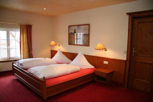 a bedroom with a bed with white pillows on it at Parkhotel Krone in Emmendingen