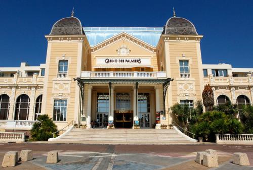 a large building with stairs in front of it at Casino Hôtel des Palmiers in Hyères