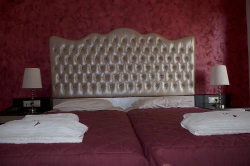 a bedroom with a large bed and two lamps at Palatino Hotel in Parga