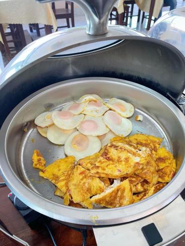a pan of food with chicken and eggs in it at Vangvieng Sisavang Mountain View Hotel in Vang Vieng