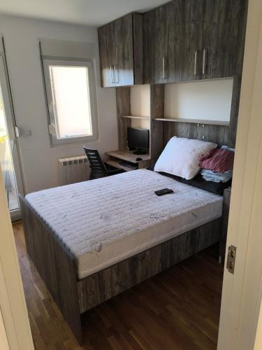 a bedroom with a large bed with a wooden headboard at Apartment for a day, Zemun, Altina, two rooms in Belgrade