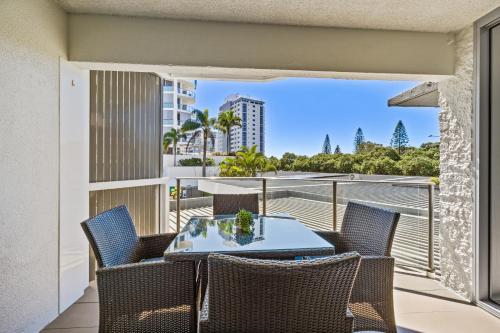 a table and chairs on a balcony with a view of the ocean at Maroochy Sands Holiday Apartments in Maroochydore