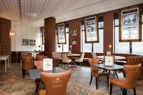 a restaurant with tables and chairs and pictures on the walls at The Shankly Hotel in Liverpool