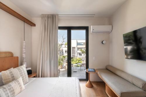 a bedroom with a bed and a couch and a window at Casa Ofelia in Mexico City
