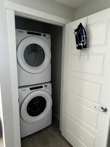 a laundry room with a washing machine and a door at The Oasis-A New 1 bed suite in Livingston Calgary close to the Airport in Calgary