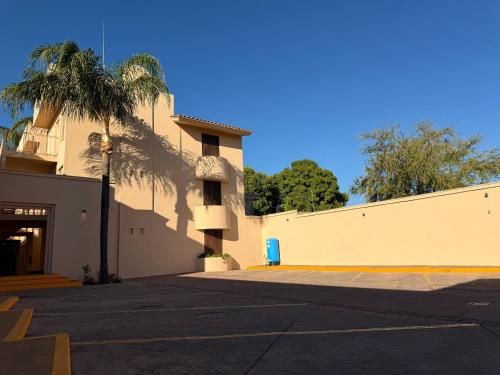 a building with a palm tree in a parking lot at Villa La Palma Hotel in Tequila