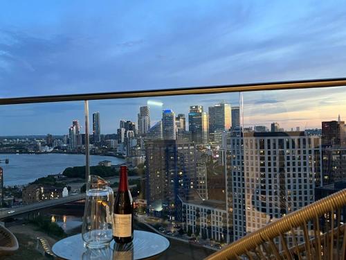 two bottles of wine sitting on a table with a view of a city at Penthouse with O2 Arena View, Free Parking & Portable AC in London
