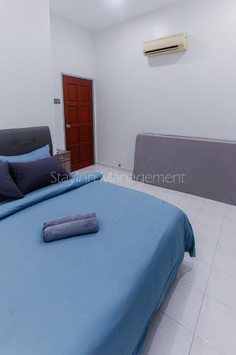 a blue bed with two pillows on top of it at PD 4R3BR 20pax Private Pool Near To the beach in Port Dickson