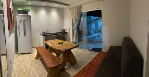 a kitchen with a wooden table and a refrigerator at Casa de praia Cajaranas in Alcobaça