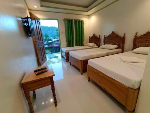 a hotel room with three beds and a balcony at Casa Santuaria in Itaytay