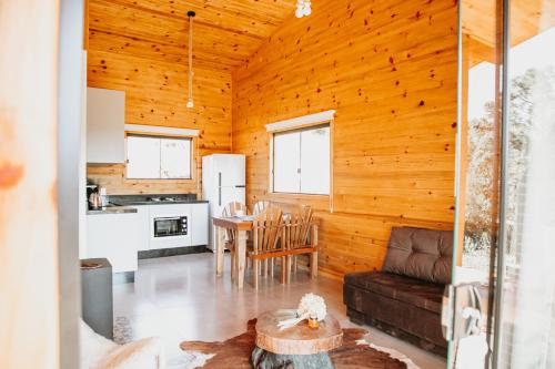 a living room with a couch and a table at Chalés Bosque das Oliveiras in Urubici