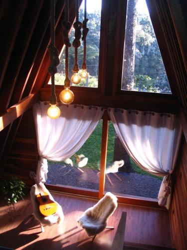 a room with a large window in a cabin at Cabana da Araucária in São Francisco de Paula