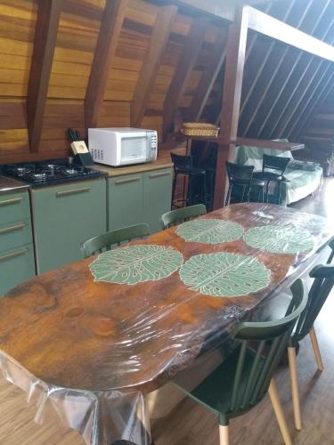 a kitchen with a wooden table with chairs around it at Cabana da Araucária in São Francisco de Paula