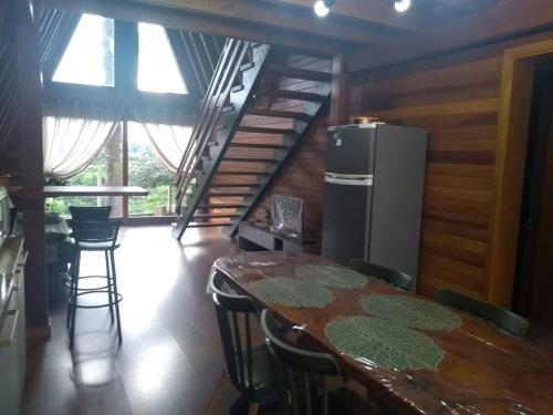 a dining room with a table and a refrigerator at Cabana da Araucária in São Francisco de Paula