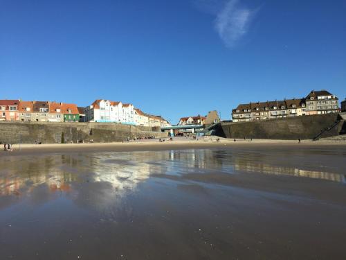 a view of a beach with buildings in the background at Hôtel-Restaurant Le Flobart in Le Portel