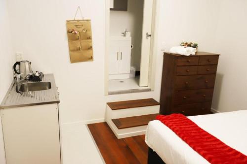 a small kitchen with a sink and a bed in a room at Aura Hotel in Wellington