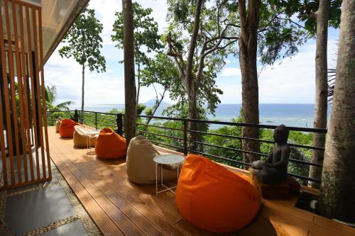 a deck with orange and white furniture on a balcony at Nayara Villa Desa Budo in Wori