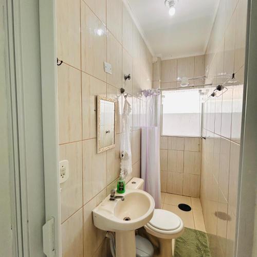 a small bathroom with a sink and a toilet at PORTO SUÍTES PERUÍBE CHECK-OUT LIVRE aos DOMINGOS in Peruíbe