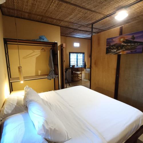 a bedroom with a large white bed in a room at Siem Reap Homesteading in Siem Reap