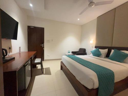 a hotel room with a large bed and a desk at Hotel Maritan - Hitech City, Hyderabad in Hyderabad