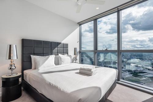 une chambre avec un grand lit avec une grande fenêtre dans l'établissement River View Central Brisbane 2-Bedroom Apartment, à Brisbane