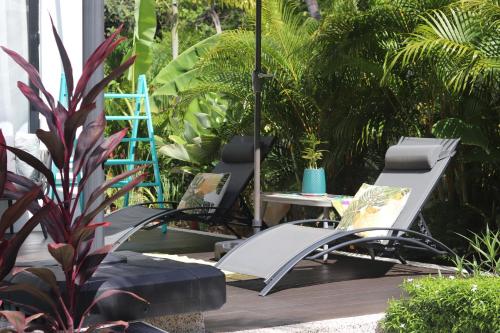 a group of chairs sitting on a wooden deck at Villa Beau Rivage in Bachok
