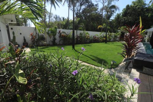 a garden with purple flowers in a yard at Villa Beau Rivage in Bachok